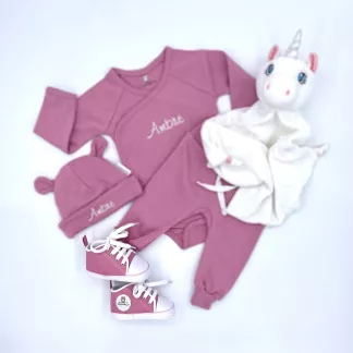 Coffret comprenant un body, un pantalon, des chaussures, un bonnet et un doudou rose.